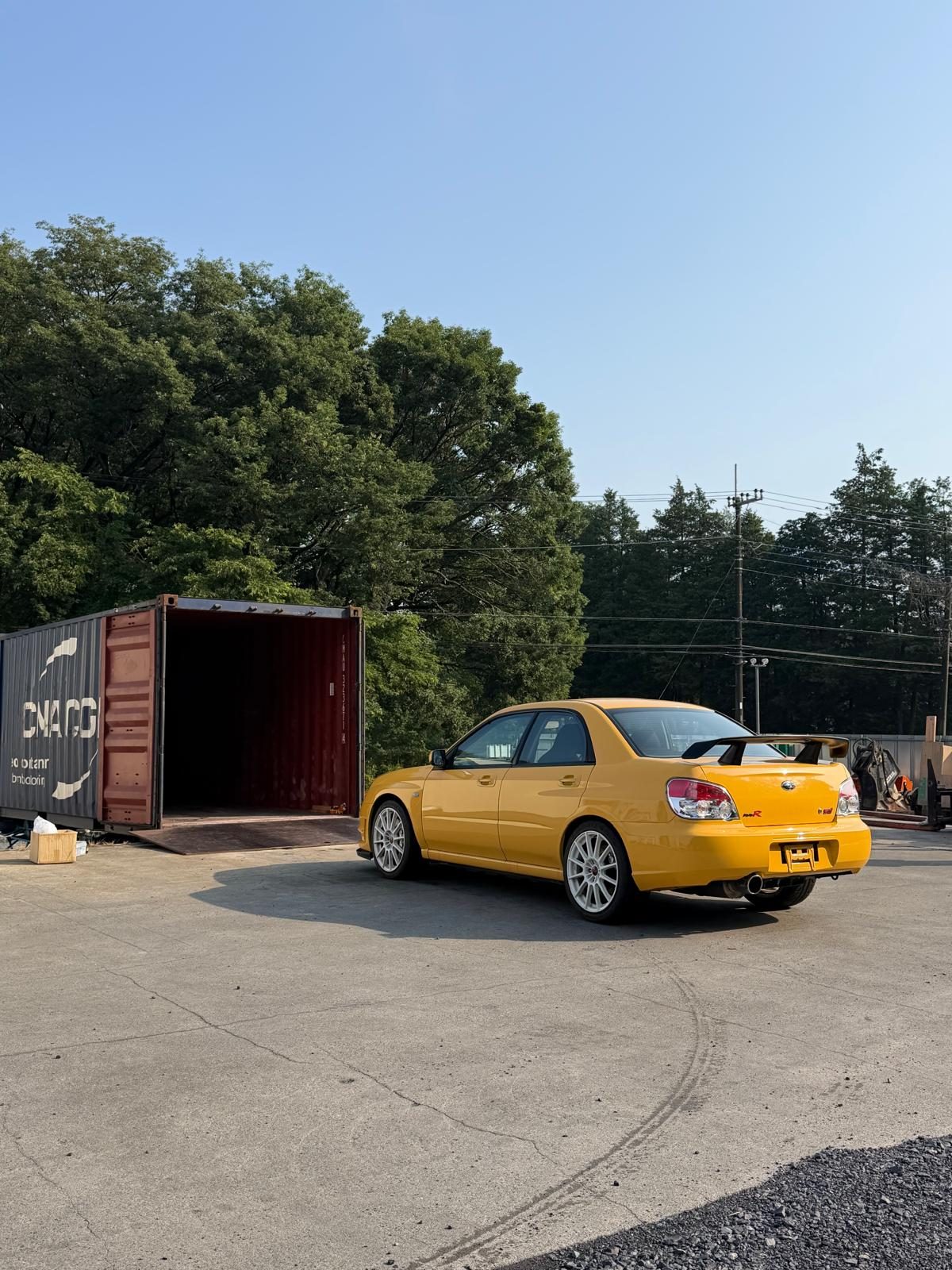 Subaru Impreza STI positioned beside an open shipping container